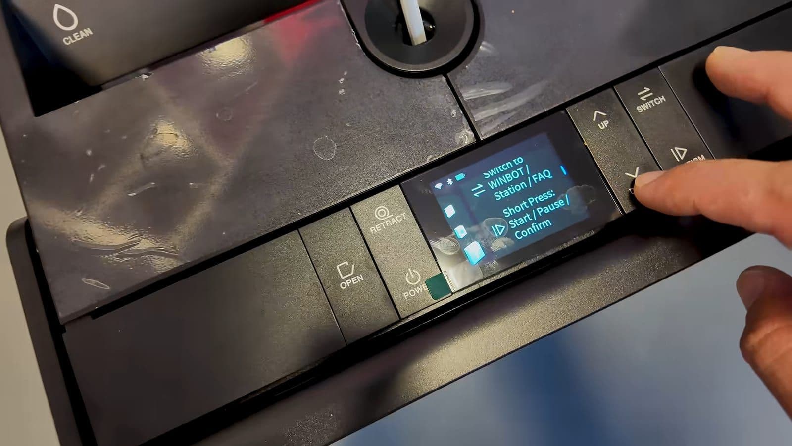 Bovenzijde van het Ecovacs station met navigatieknoppen en menuscherm