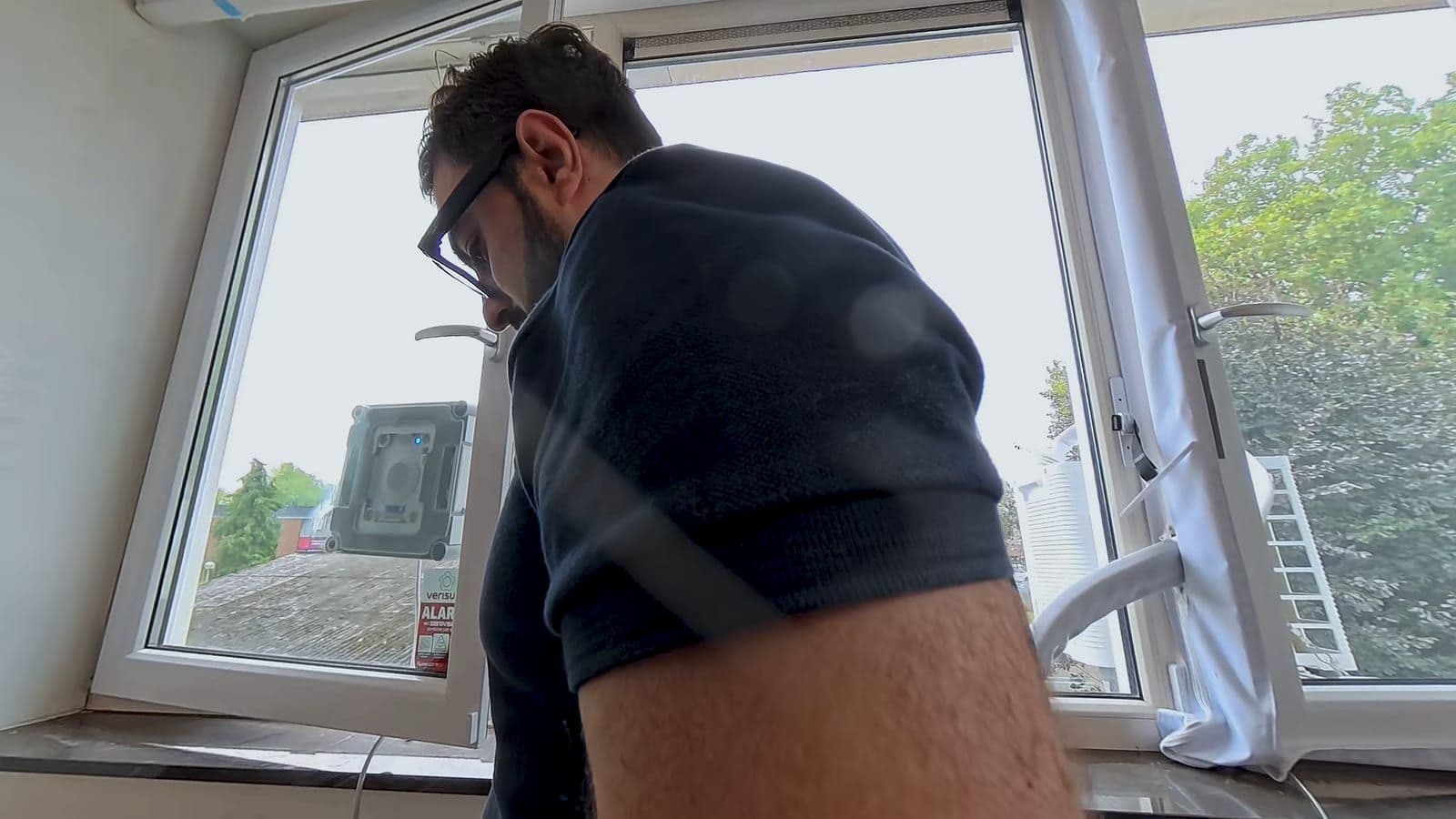 De robot poetst de buitenkant van het raam terwijl de veiligheidskabel omlaag hangt
