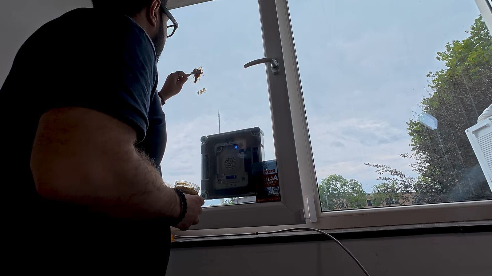 Zino smeert met een lepel een dikke laag pindakaas op de ruit