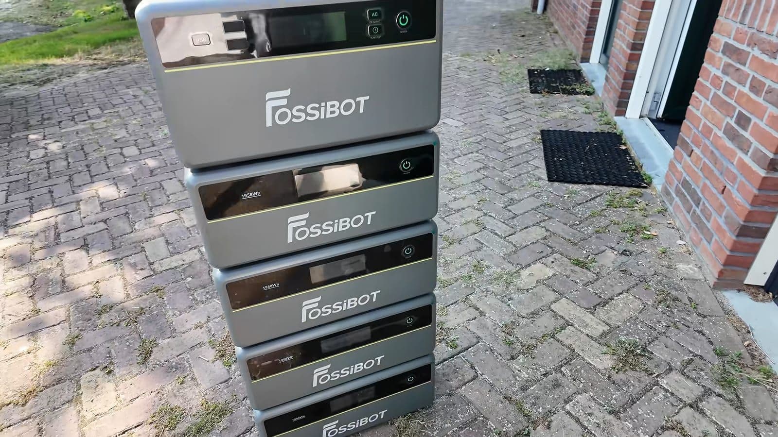 Fossibot FBP1200 basisunit met vier uitbreidingsbatterijen gestapeld op een klinkerpad