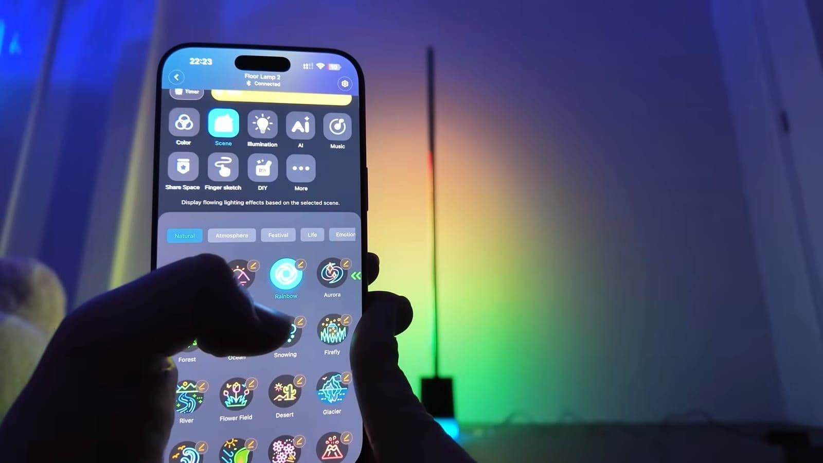 A smartphone running the Govee Home app held up in front of the Floor Lamp 2