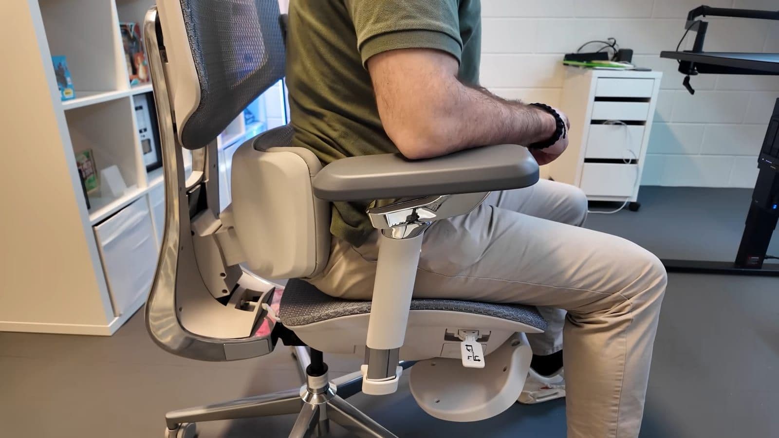 Profile shot of Zino sitting in the Hbada X7 testing the armrests and motorized back mechanism