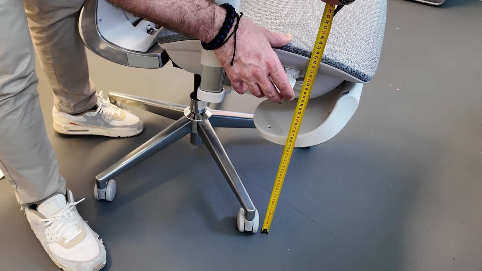 Measuring tape placed against the side of the Hbada X7 showing the 53 cm seat height mark