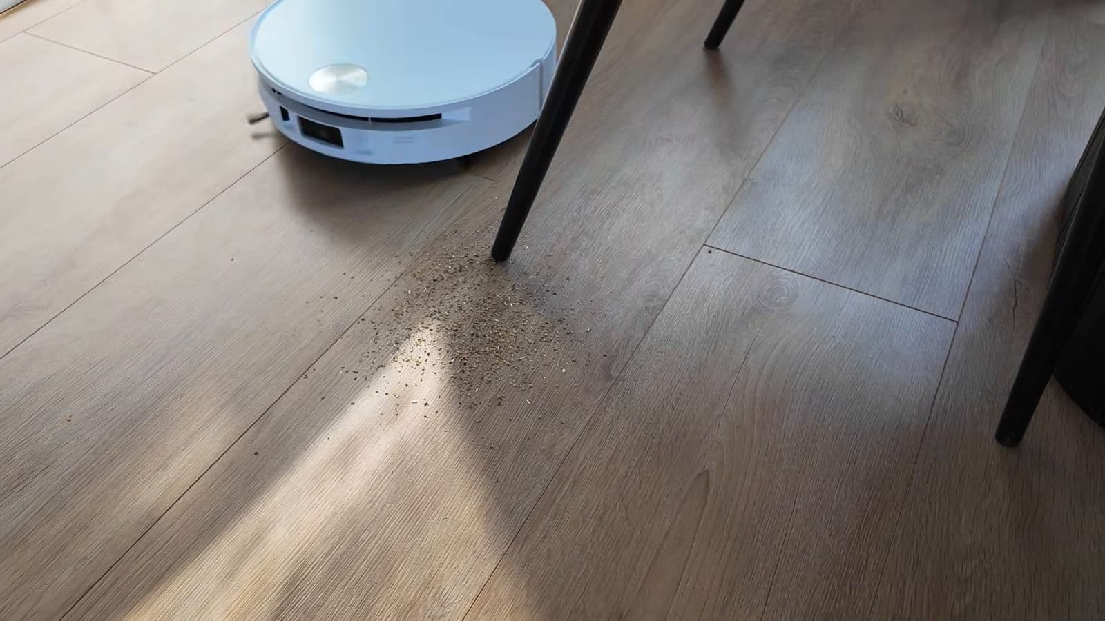 De uitschuifbare zijborstel veegt vuil weg rondom een schuine tafelpoot