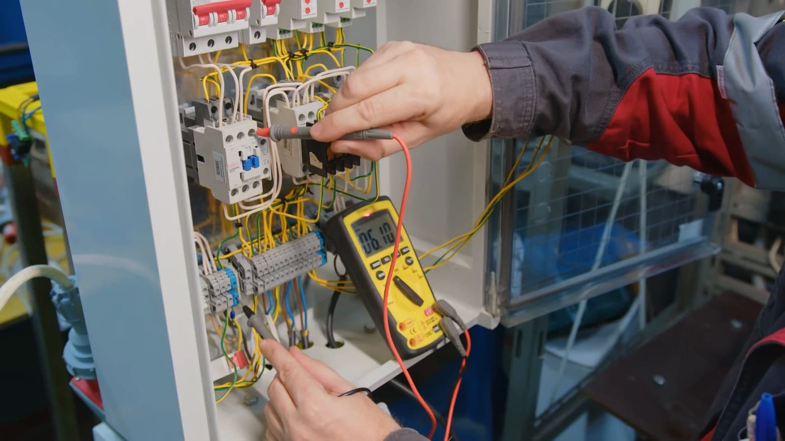 Een installateur meet spanningen in een groepenkast met een multimeter